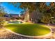 Inviting backyard oasis with a sparkling pool, lush turf, and landscape lighting for evening enjoyment at 3603 E Salter Dr, Phoenix, AZ 85050