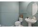 Powder room featuring beadboard paneling, a pedestal sink, and a decorative round mirror at 3603 E Salter Dr, Phoenix, AZ 85050