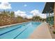 Lap pool with lane markers and brick wall exterior featuring surrounding trees and sunshine at 3603 E Salter Dr, Phoenix, AZ 85050