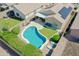 Backyard features a pool, artificial grass, paver patio, and covered seating area at 3612 W Charlotte Dr, Glendale, AZ 85310