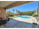 Resort-style backyard featuring a sparkling pool, stone patio, lush landscaping, and a covered outdoor seating area at 3612 W Charlotte Dr, Glendale, AZ 85310
