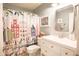 Stylish bathroom with a colorful shower curtain, white vanity, and modern fixtures at 3612 W Charlotte Dr, Glendale, AZ 85310