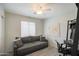 Stylish bedroom with a comfortable couch, a modern ceiling fan, and a dedicated workspace for enhanced productivity at 3612 W Charlotte Dr, Glendale, AZ 85310
