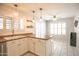 Charming kitchen with stylish lighting, white cabinets, an island with barstool seating, and tile floors at 3612 W Charlotte Dr, Glendale, AZ 85310