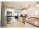 Bright kitchen with stainless steel appliances, white cabinetry, granite countertops, and easy access to the living area at 3612 W Charlotte Dr, Glendale, AZ 85310