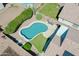 Aerial view of a pool with paver patio, artificial grass, and desert landscaping at 3612 W Charlotte Dr, Glendale, AZ 85310