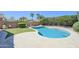 Refreshing pool surrounded by a stone deck, green grass, and lush landscaping at 3612 W Charlotte Dr, Glendale, AZ 85310