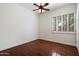 Minimalist bedroom with a ceiling fan, hardwood floors, and shuttered windows at 3671 S Greythorne Way, Chandler, AZ 85248