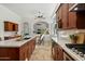 Elegant kitchen featuring stone floors, light countertops, wood cabinets, and views to other rooms at 3671 S Greythorne Way, Chandler, AZ 85248