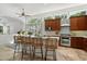 Bright kitchen features stainless steel appliances, wood cabinets, tile flooring, and wicker counter chairs at 3671 S Greythorne Way, Chandler, AZ 85248