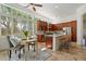 Bright kitchen with tile floors, wood cabinets, island with sink and wicker counter chairs and a small eating table at 3671 S Greythorne Way, Chandler, AZ 85248