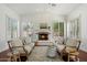 Bright living room with brick fireplace, white mantel, hardwood floors, white walls, and white couches at 3671 S Greythorne Way, Chandler, AZ 85248