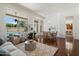 Open-concept living room with hardwood floors, chandelier, large windows, and view to the kitchen and pool at 3671 S Greythorne Way, Chandler, AZ 85248