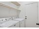 Well-equipped laundry room showcasing a Maytag washer and dryer, shelving, and easy access to the exterior at 3898 E San Remo Ave, Gilbert, AZ 85234