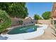 Private backyard pool with rock waterfall feature, surrounded by lush greenery and a charming patio set at 3898 E San Remo Ave, Gilbert, AZ 85234