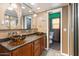 Modern bathroom with dual bowl sinks, granite countertop, and an adjacent toilet room at 3919 S Siesta Ln, Tempe, AZ 85282