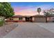 Charming brick home featuring a paved driveway and mature landscaping, under a vibrant sunset sky at 3919 S Siesta Ln, Tempe, AZ 85282