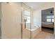 Bright bathroom showcasing a glass-enclosed shower and a soaking tub beneath a sunlit window at 4084 E Caitlin Dr, San Tan Valley, AZ 85140
