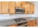 Kitchen detail showcasing granite countertops, stainless steel microwave, gas cooktop, and modern oven at 4084 E Caitlin Dr, San Tan Valley, AZ 85140