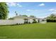 Extensive backyard with a well-maintained lawn, privacy wall, and various trees, offering a serene outdoor space at 4916 E Flower St, Phoenix, AZ 85018
