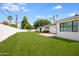 Spacious backyard with healthy lawn, paver patio, and white privacy wall, perfect for outdoor living at 4916 E Flower St, Phoenix, AZ 85018