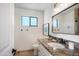 Well-lit half bathroom featuring granite countertops, framed mirror, and white cabinets at 4916 E Flower St, Phoenix, AZ 85018