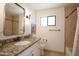 Inviting bathroom featuring stone tilework, granite vanity, and a large mirror and tub at 4916 E Flower St, Phoenix, AZ 85018