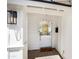 Charming white door and brick entryway with a lantern and view into the home at 4916 E Flower St, Phoenix, AZ 85018