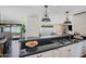 Open-concept kitchen with a black countertop island and views of the backyard and living areas at 4916 E Flower St, Phoenix, AZ 85018