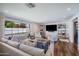 Bright and airy living room with a large window, comfortable seating, and decorative shelves at 4916 E Flower St, Phoenix, AZ 85018