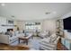 Bright living room with a white brick fireplace, hardwood floors, a neutral couch, and two chairs at 4916 E Flower St, Phoenix, AZ 85018