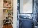 Well-stocked pantry with organized shelving and vintage door with peeling paint at 4916 E Flower St, Phoenix, AZ 85018