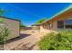 View of the home's gravel backyard featuring a shed, covered patio, and some greenery at 5627 E Covina Rd, Mesa, AZ 85205