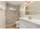Modern bathroom with stone and marble tiled shower, vanity, toilet, and modern lighting at 5627 E Covina Rd, Mesa, AZ 85205