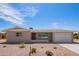 Single story home with desert landscaping, a concrete driveway and an attached two car garage at 6043 E Des Moines St, Mesa, AZ 85205