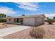 Tan single story home with desert landscaping, long driveway and an attached two car garage at 6043 E Des Moines St, Mesa, AZ 85205