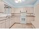 Cozy kitchen with ample cabinetry, white appliances, and a window over the sink at 6043 E Des Moines St, Mesa, AZ 85205