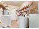Functional laundry area with washer, dryer, shelving, and door with screen; ready for everyday tasks at 6043 E Des Moines St, Mesa, AZ 85205