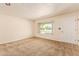Inviting living room with neutral carpet, a large window, and a white front door at 6043 E Des Moines St, Mesa, AZ 85205