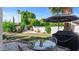 Backyard featuring a well-manicured lawn, shade trees, a patio with seating, and a BBQ at 6126 E Paradise Ln, Scottsdale, AZ 85254