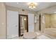 Bright bathroom featuring double doors, a large mirror, a walk-in shower, and a soaking tub at 6126 E Paradise Ln, Scottsdale, AZ 85254