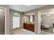 Bathroom featuring tiled floors, arched window, double vanity and access to the main bedroom at 6126 E Paradise Ln, Scottsdale, AZ 85254