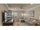 Comfortable bedroom with a gray sofa, neutral walls, a ceiling fan, and a view of the landscaped exterior at 6126 E Paradise Ln, Scottsdale, AZ 85254