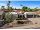 Single-story home boasting a three-car garage and desert landscaping for a low-maintenance appeal at 6126 E Paradise Ln, Scottsdale, AZ 85254