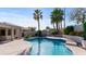 Beautiful pool with a curved edge, surrounded by a concrete patio and palm trees at 6126 E Paradise Ln, Scottsdale, AZ 85254