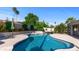 Sparkling blue pool surrounded by lush greenery and tall palm trees for a private oasis at 6126 E Paradise Ln, Scottsdale, AZ 85254