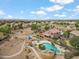 Stunning aerial view of a desert neighborhood with a community pool, playground, and desert landscaping at 6713 E Riverdale St, Mesa, AZ 85215