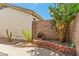 A brick wall encloses the yard, and a small water feature and cacti add a splash of color at 6713 E Riverdale St, Mesa, AZ 85215