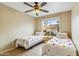 Cozy bedroom with twin beds, tile floors, a ceiling fan, and a bright window at 6713 E Riverdale St, Mesa, AZ 85215
