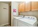 Functional laundry area with cabinets and a washer-dryer set for convenience at 6713 E Riverdale St, Mesa, AZ 85215